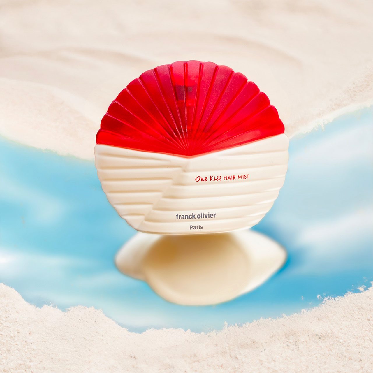 Le flacon One Kiss Hait Mist posé sur l'eau